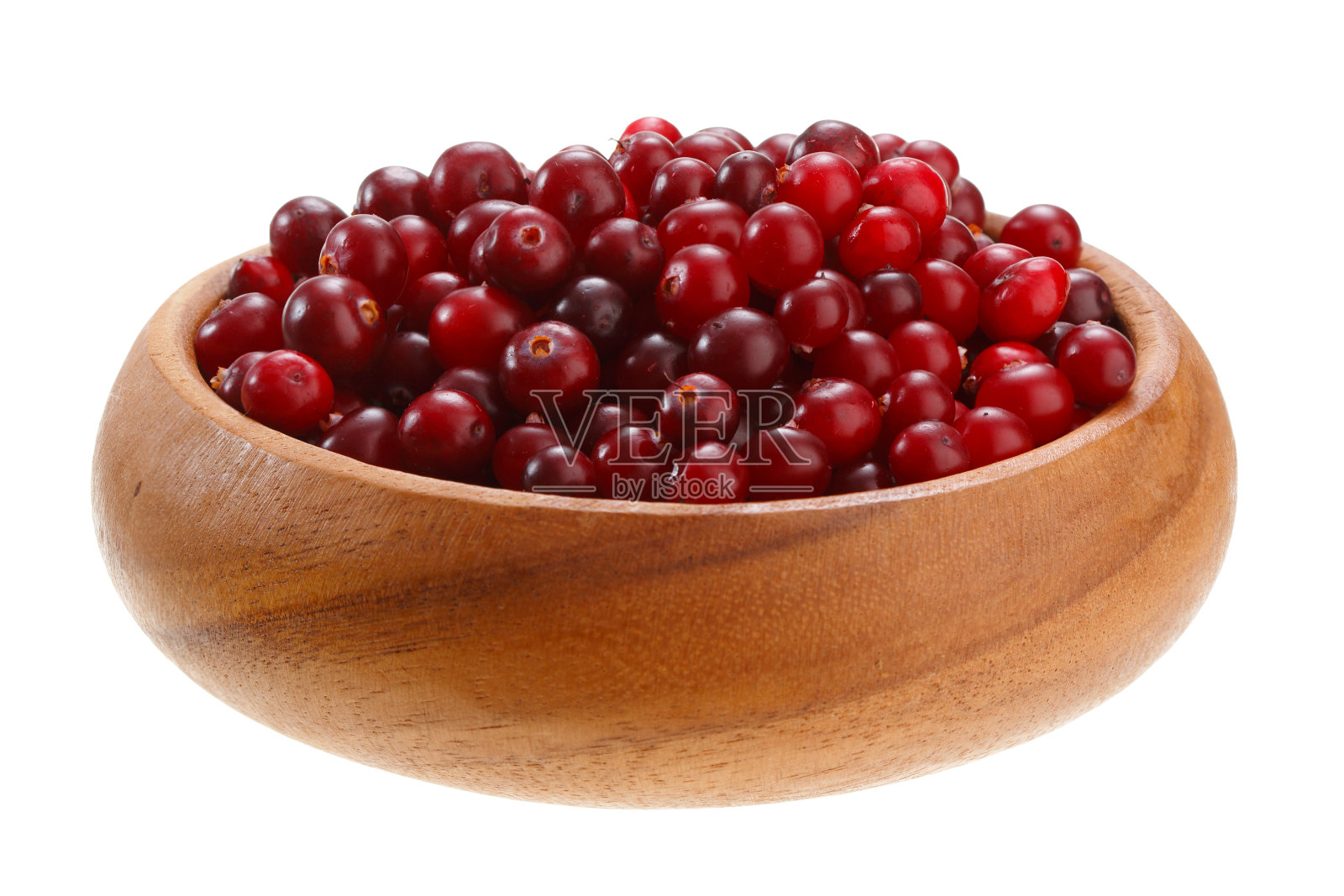 小红莓放在一个木碗里，孤立在白色的背景上照片摄影图片