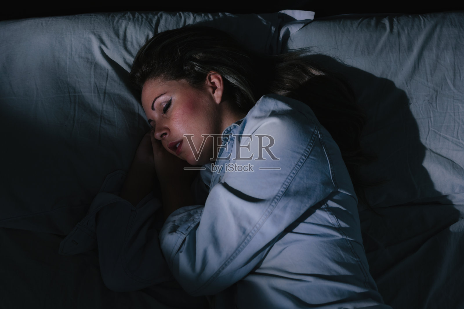 晚上平静地睡在床上的女人照片摄影图片