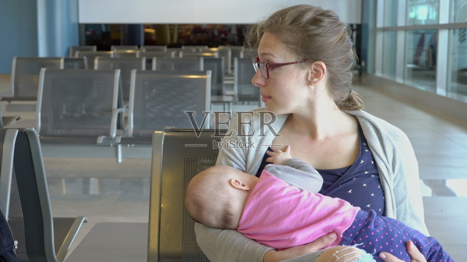 一名妇女在机场哺乳她的孩子照片摄影图片