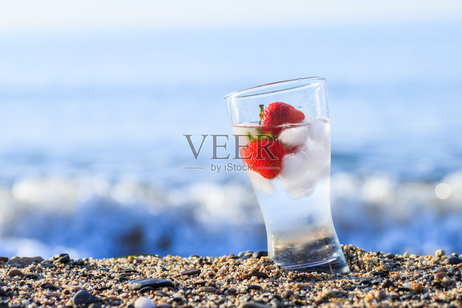 冷冻草莓和海边的纯净水。照片摄影图片