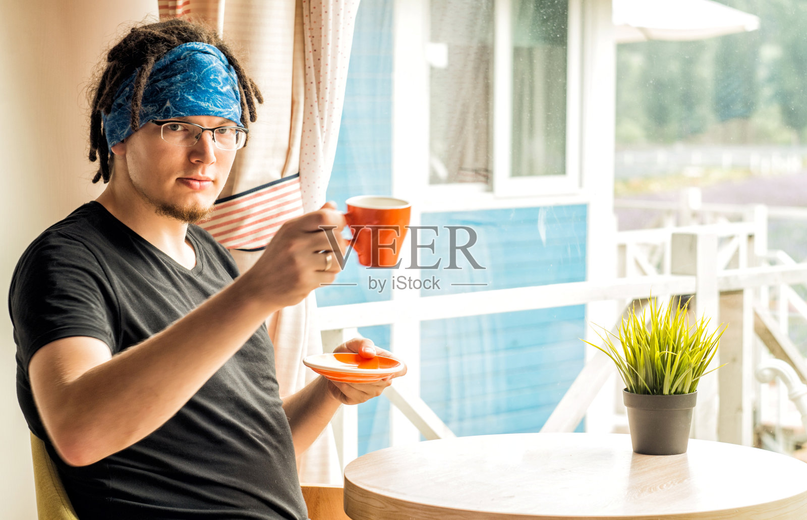 一个留着长发绺的男人正在家里喝咖啡照片摄影图片