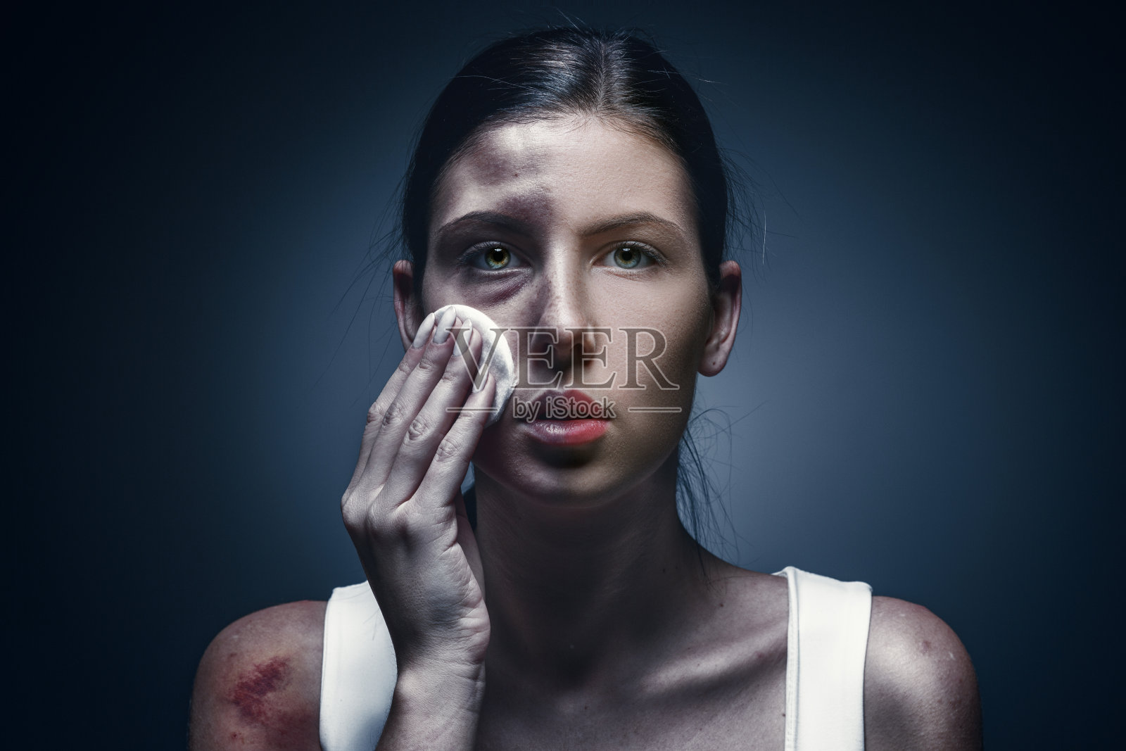 一个哭泣的女人的特写，皮肤青肿，眼睛黑照片摄影图片