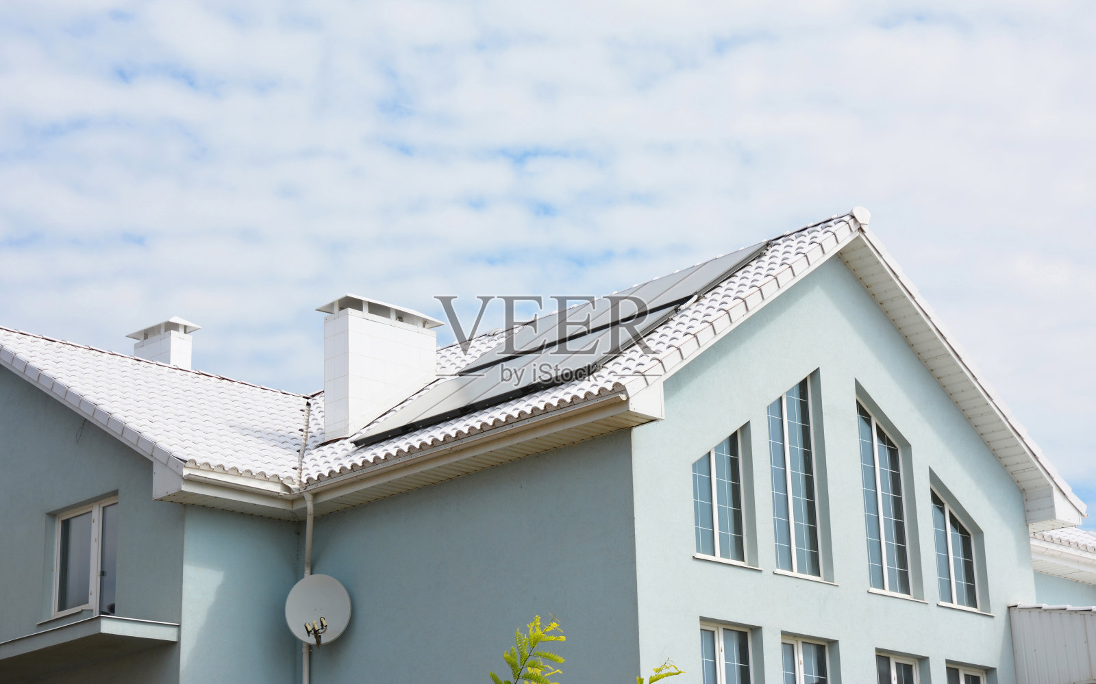 白色粘土瓦屋顶和太阳能电池板，太阳能热水器的房屋能源效率。白色屋顶带来凉爽节省，可以减少空调成本高达20%。照片摄影图片