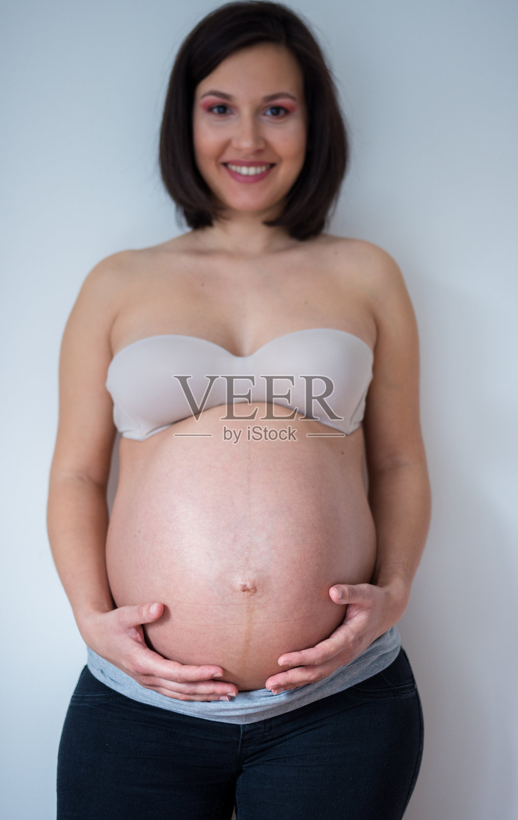 一个女人摆着怀孕的肚子照片摄影图片