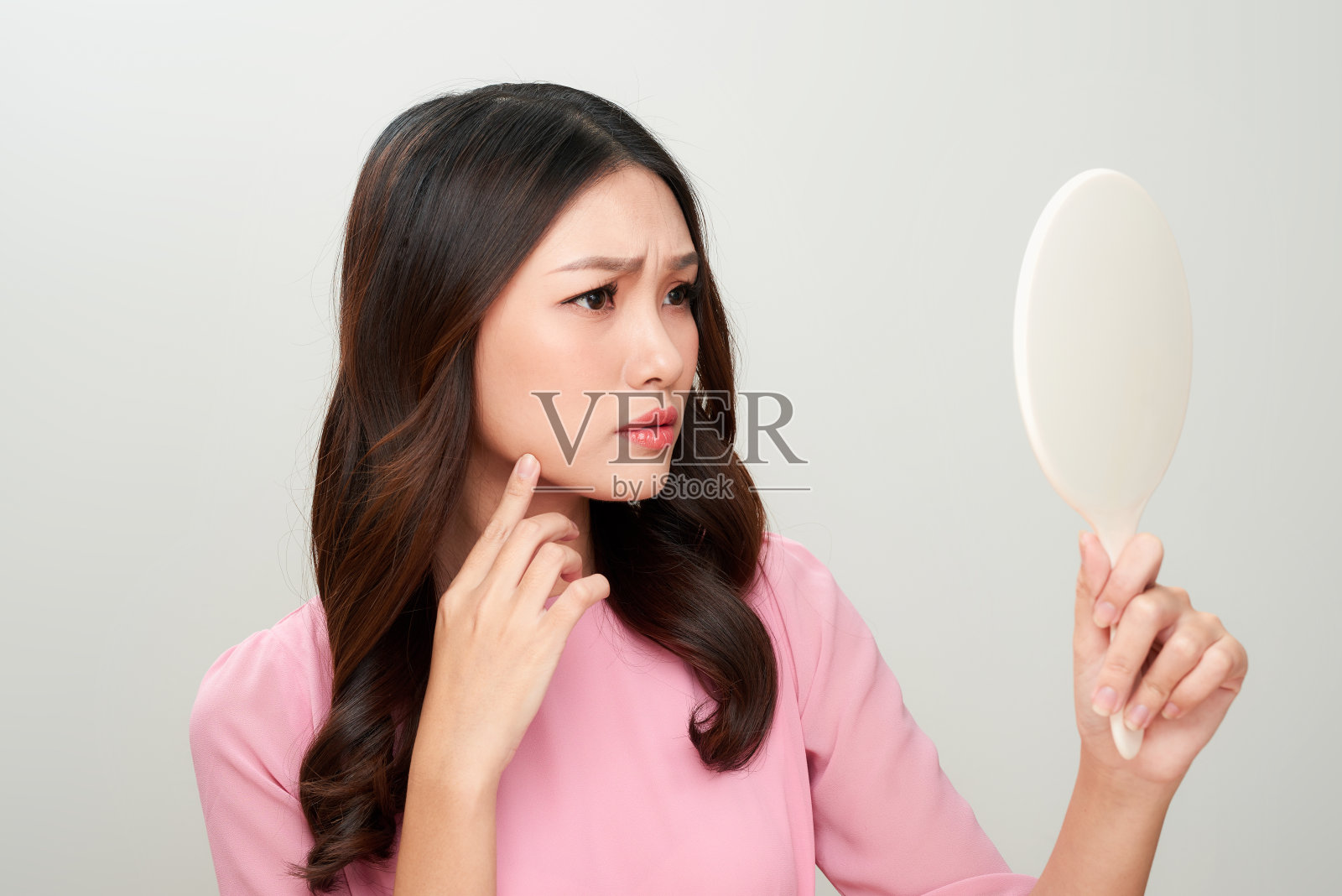 一个皮肤上有问题的亚洲女人看着镜子。照片摄影图片