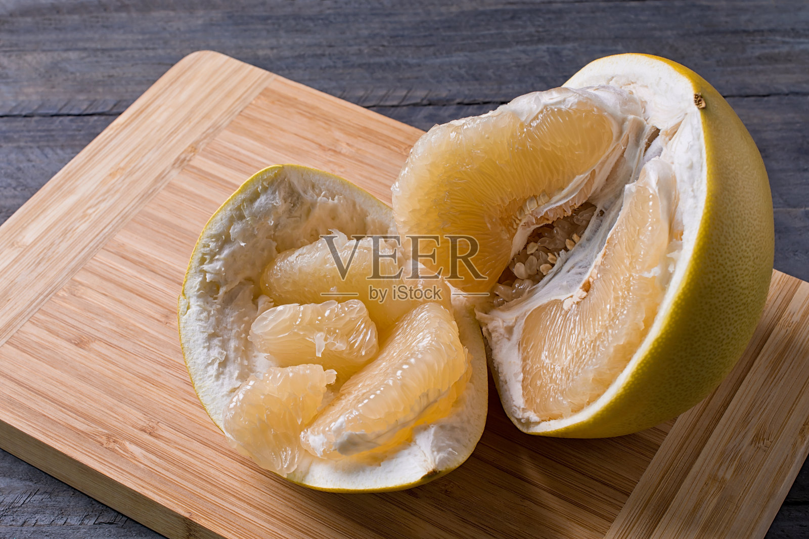 特写的甜柚剥皮在木制的背景。照片摄影图片