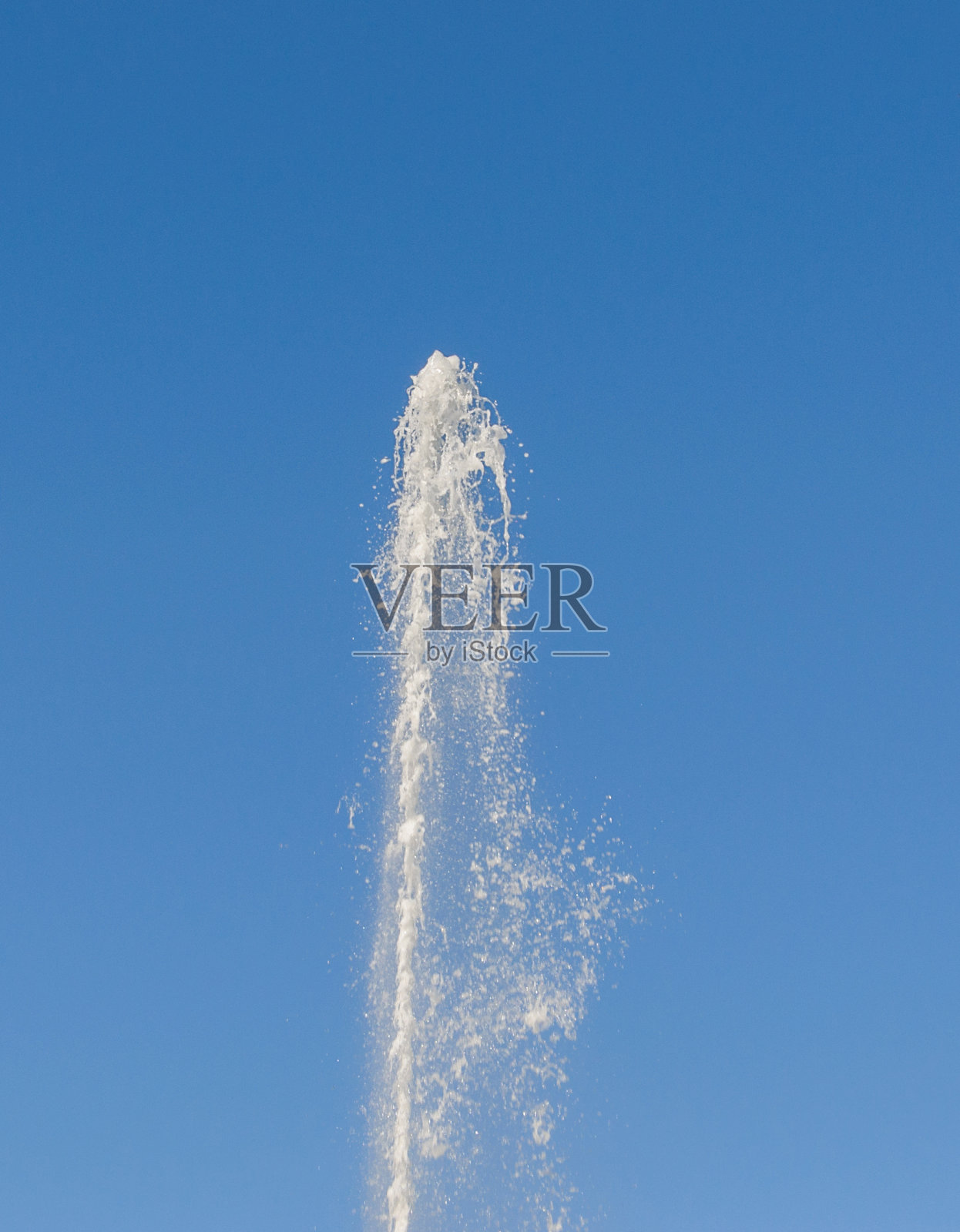 在蓝天的背景下，一股纯净水在压力下喷涌而出照片摄影图片