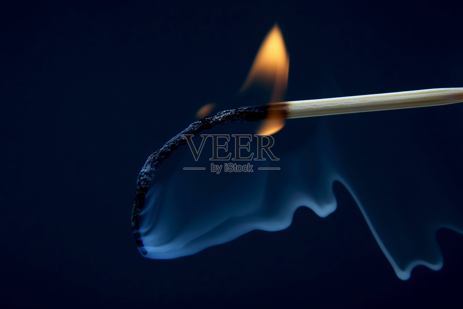 燃烧和冒烟的木头火柴在黑暗的背景照片摄影图片