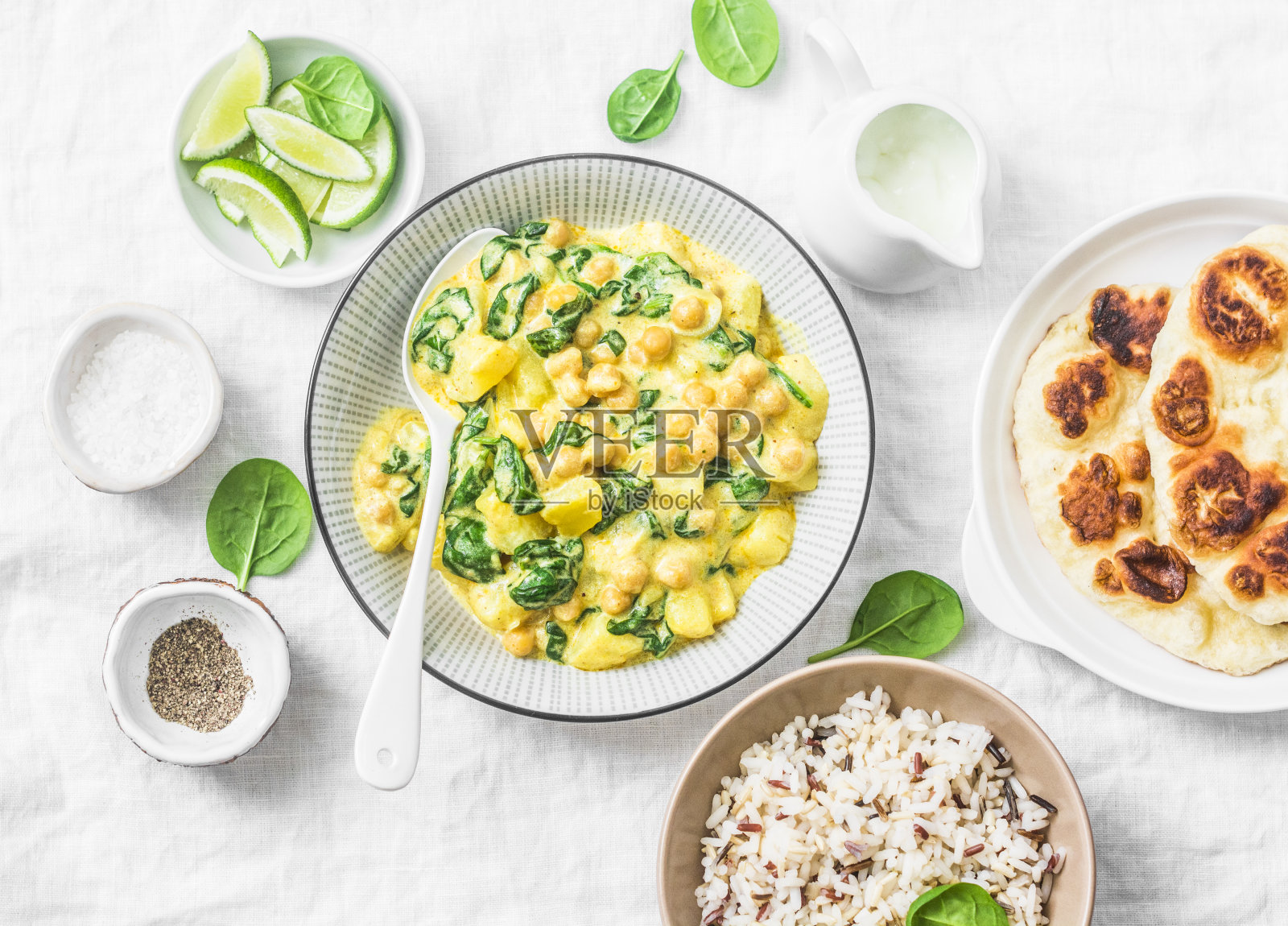 素食鹰嘴豆，菠菜，咖喱土豆，印度烤饼和菰米在白色背景，俯视图。印度健康食品概念照片摄影图片