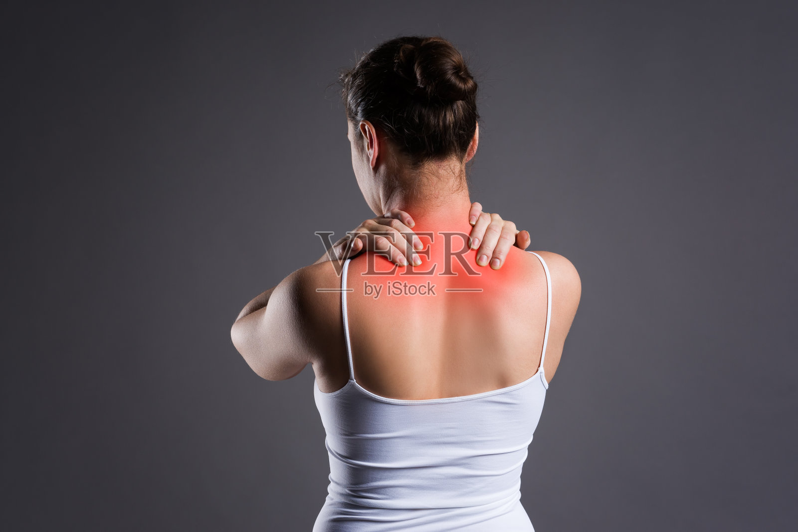 颈部疼痛，灰色背景下的背痛女性照片摄影图片