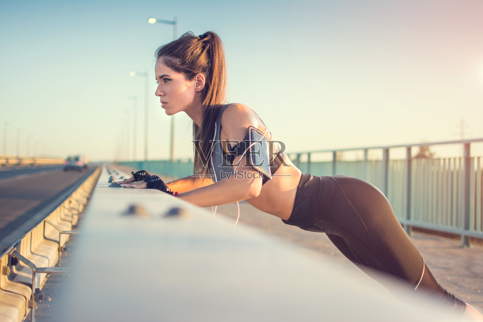 迷人的年轻运动女孩伸展身体和做俯卧撑过桥栏照片摄影图片
