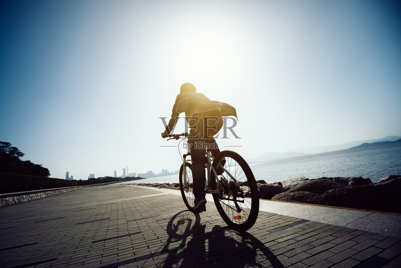 骑自行车的人在日出的海岸公路上骑自行车照片摄影图片