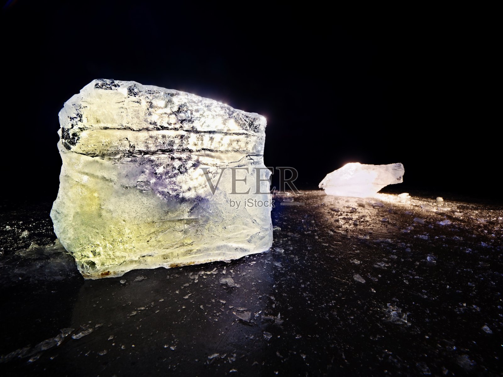 浮冰和碎冰在黑暗的冻结和平坦的地面上。闪亮的碎冰照片摄影图片
