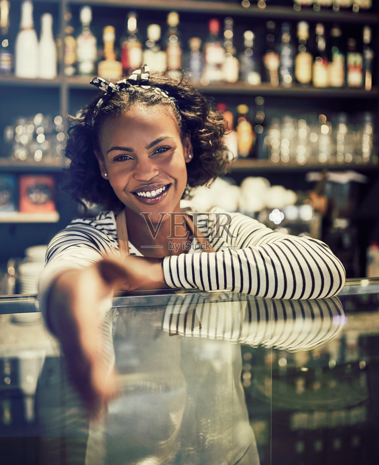 微笑的非洲企业家在她的咖啡馆柜台后面握手照片摄影图片