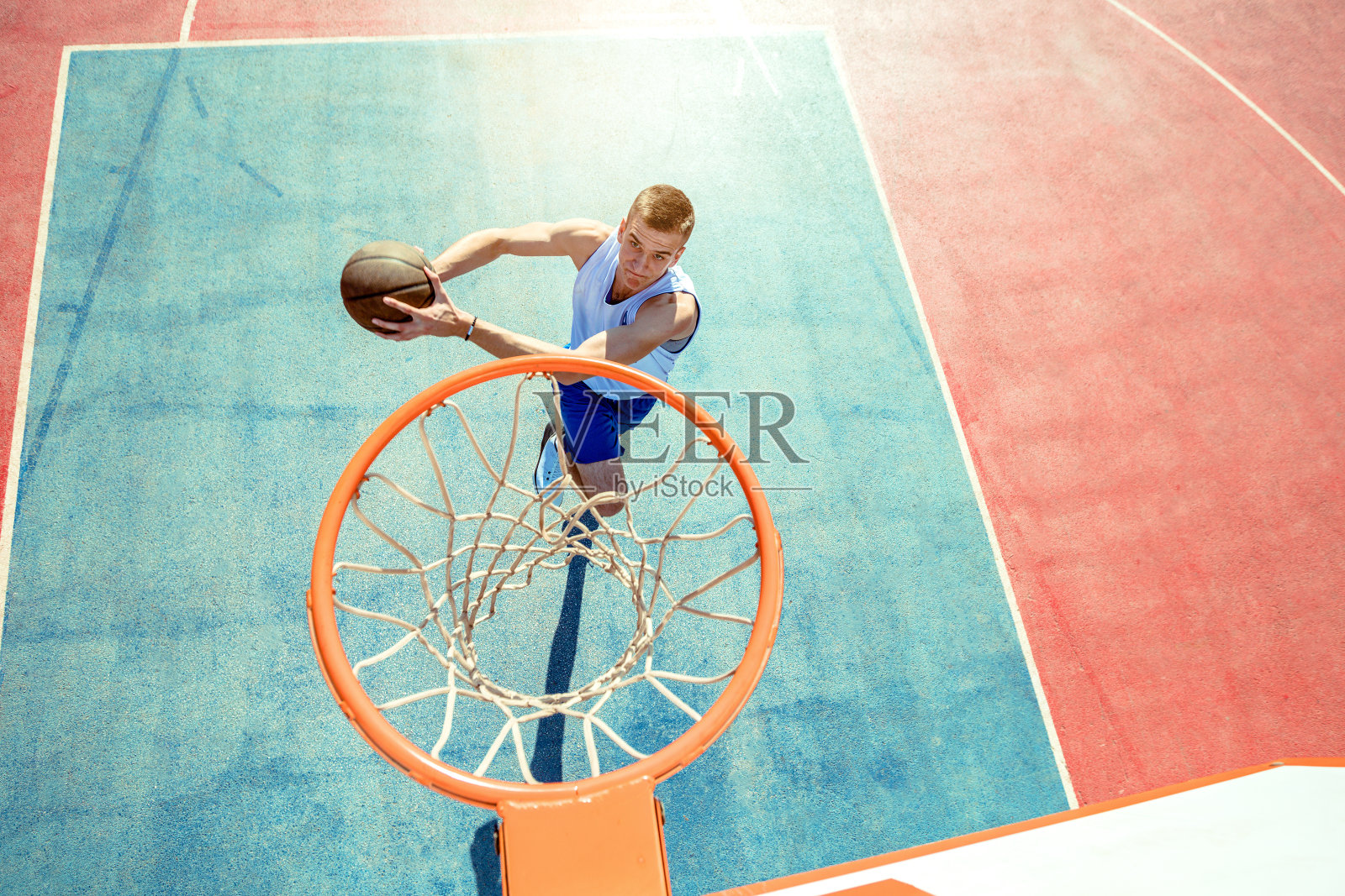 年轻人在打街球，篮球的时候跳起来，做了一个精彩的扣篮。城市的真实。照片摄影图片