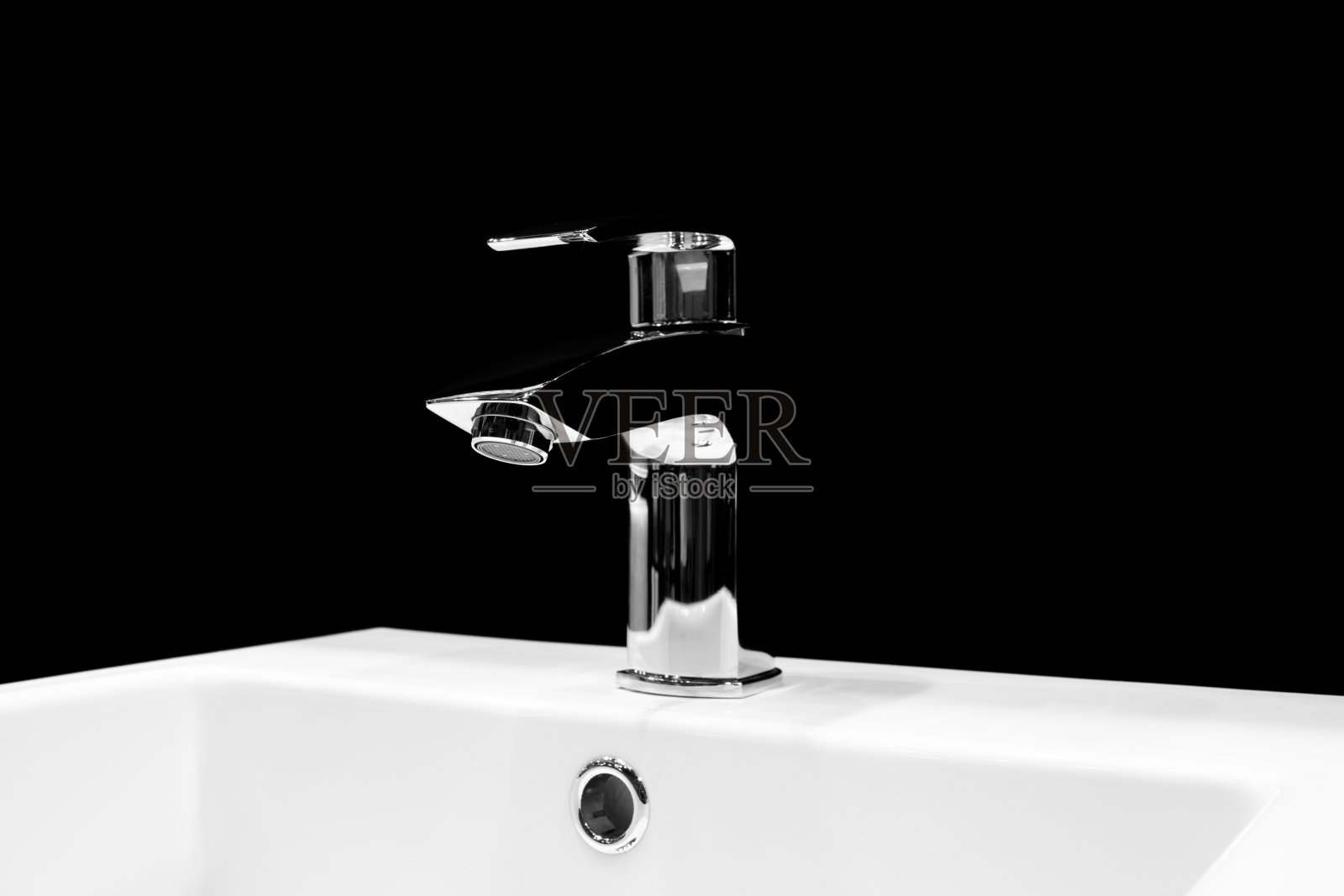 豪华水龙头搅拌器在一个美丽的黑色浴室的白色水槽照片摄影图片