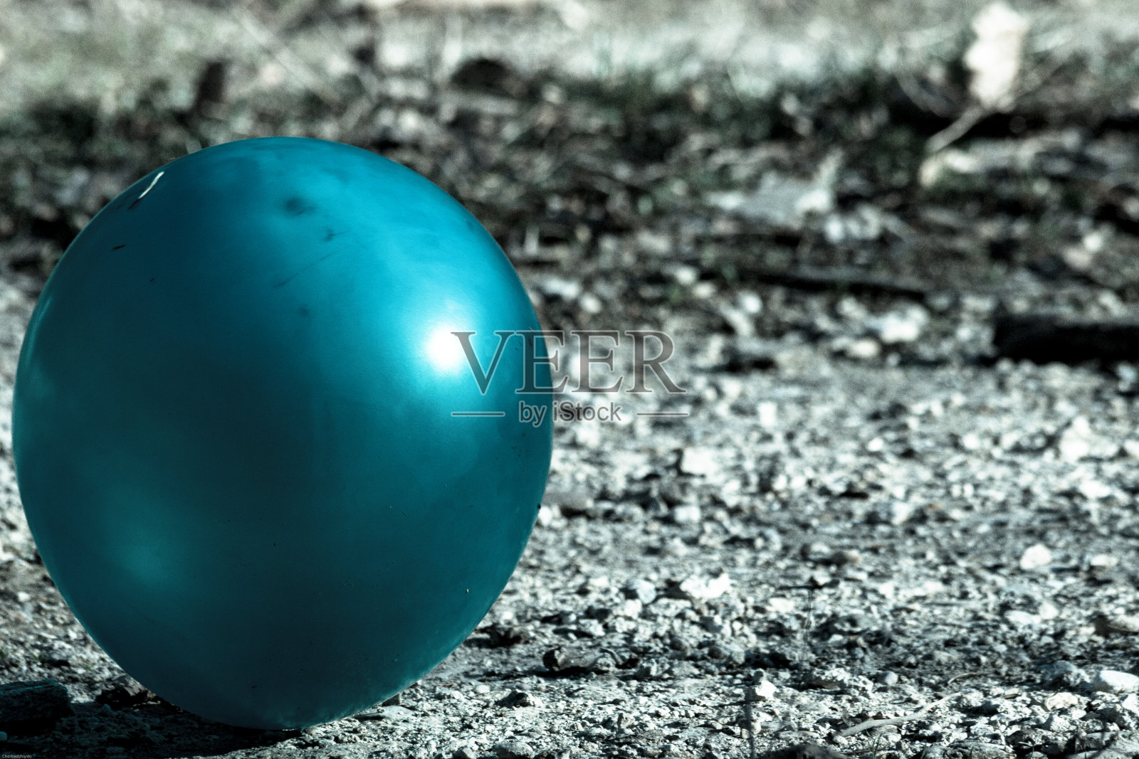 孤独的蓝色气球在危险的地面上爬行，充满了随时可能爆发出来的恐惧照片摄影图片