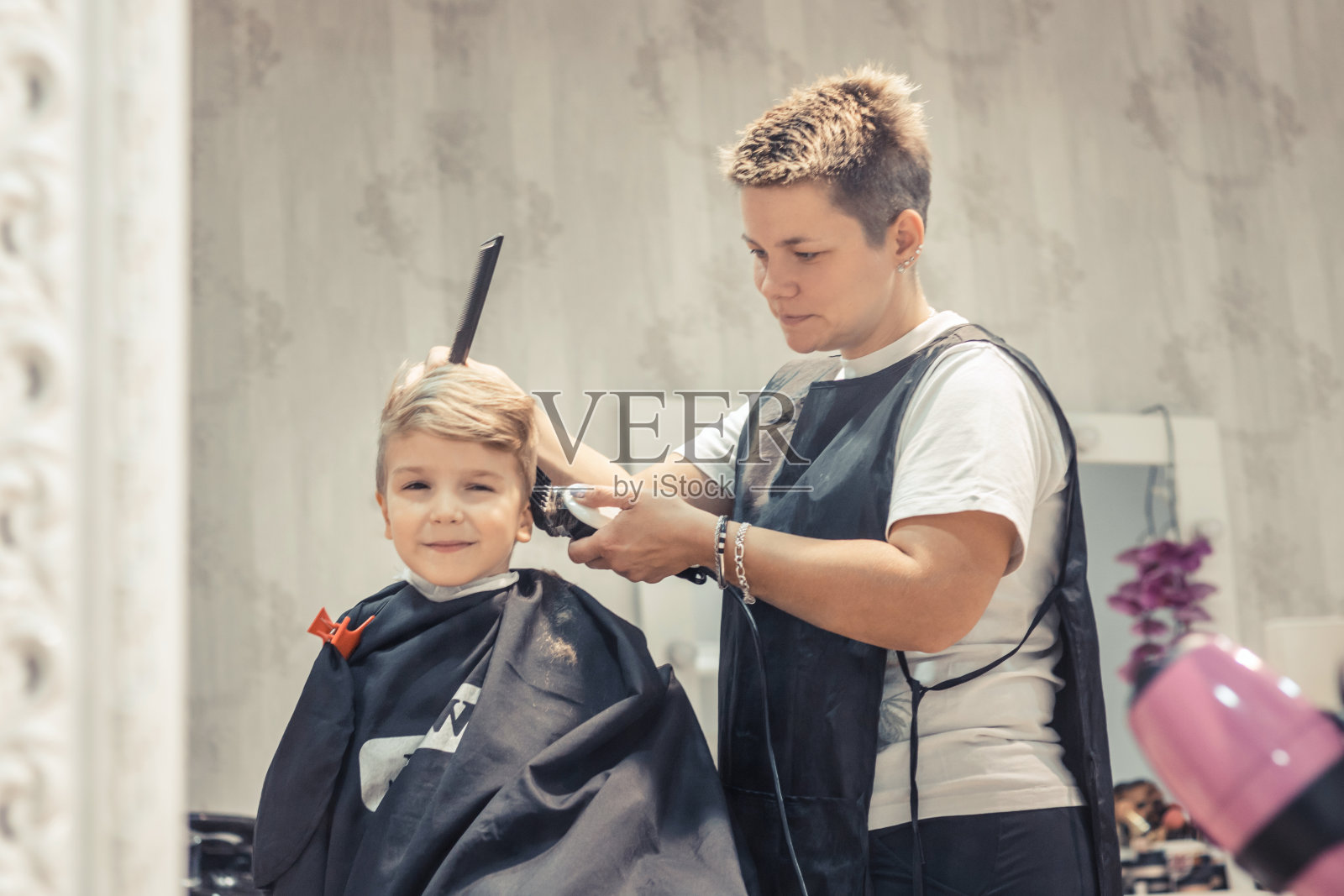 小男孩在理发店理发。照片摄影图片