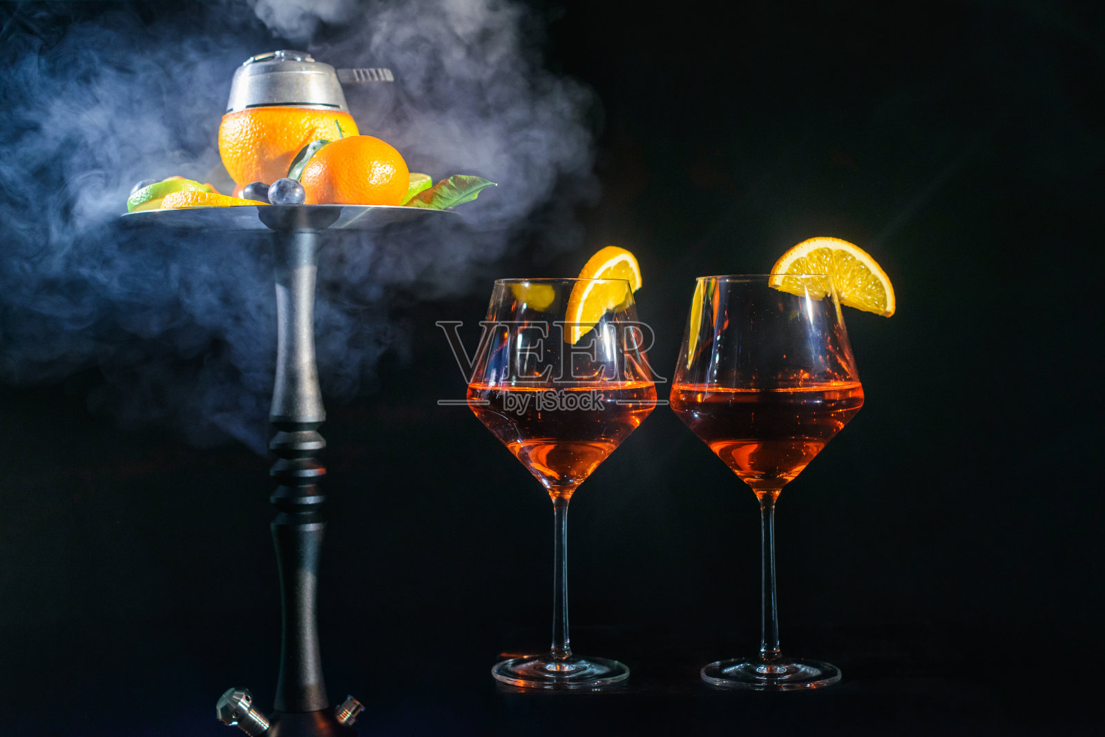 两杯Aperol香槟或鸡尾酒或葡萄和水烟shisha与水果碗孤立在黑色背景与橙色小叶烟飘飘派对庆祝主题照片摄影图片