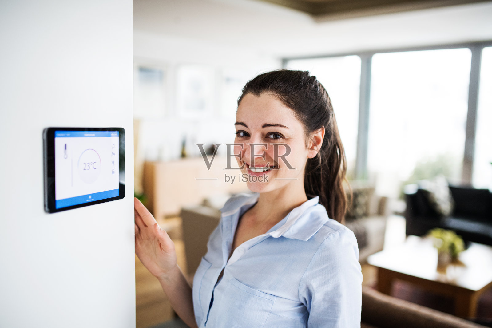 一位女士正在看带有智能主屏幕的平板电脑。照片摄影图片