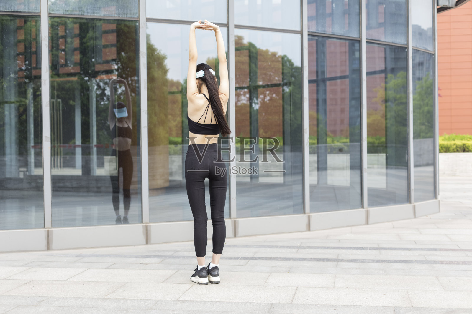 女人在玻璃建筑前做热身照片摄影图片