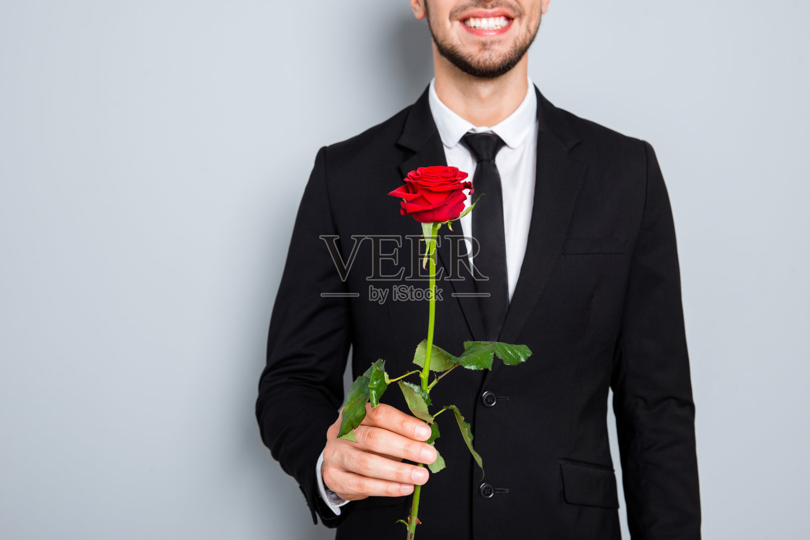 近距离拍摄的快乐微笑的商人与红玫瑰照片摄影图片