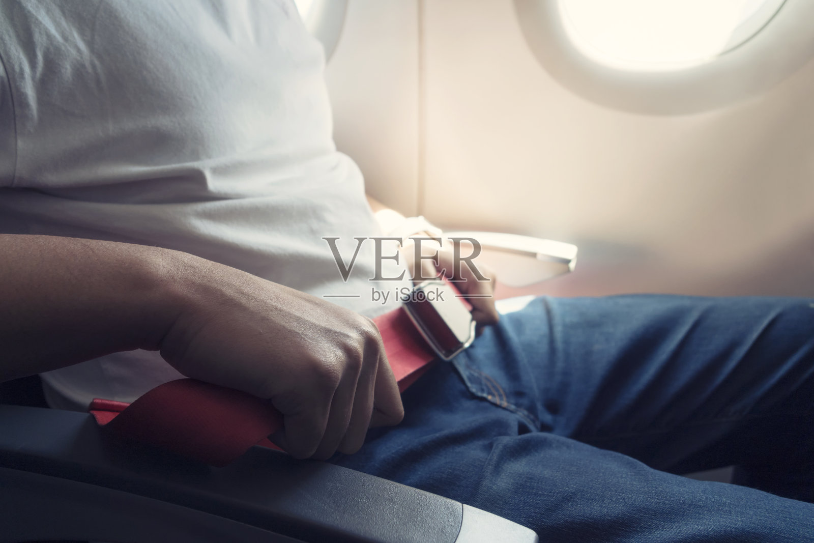 为了安全飞行，乘客坐在飞机上时请系好安全带。安全旅行。照片摄影图片