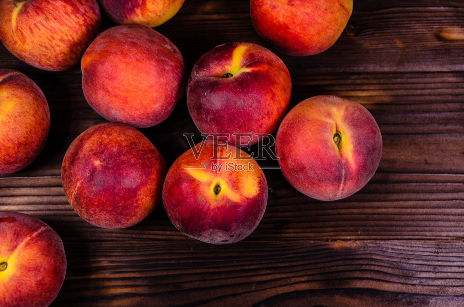 新鲜成熟的桃子放在木桌上。俯视图照片摄影图片