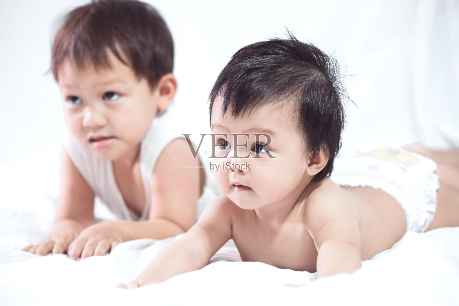 可爱的亚洲小女孩和她的弟弟一起躺在床上照片摄影图片