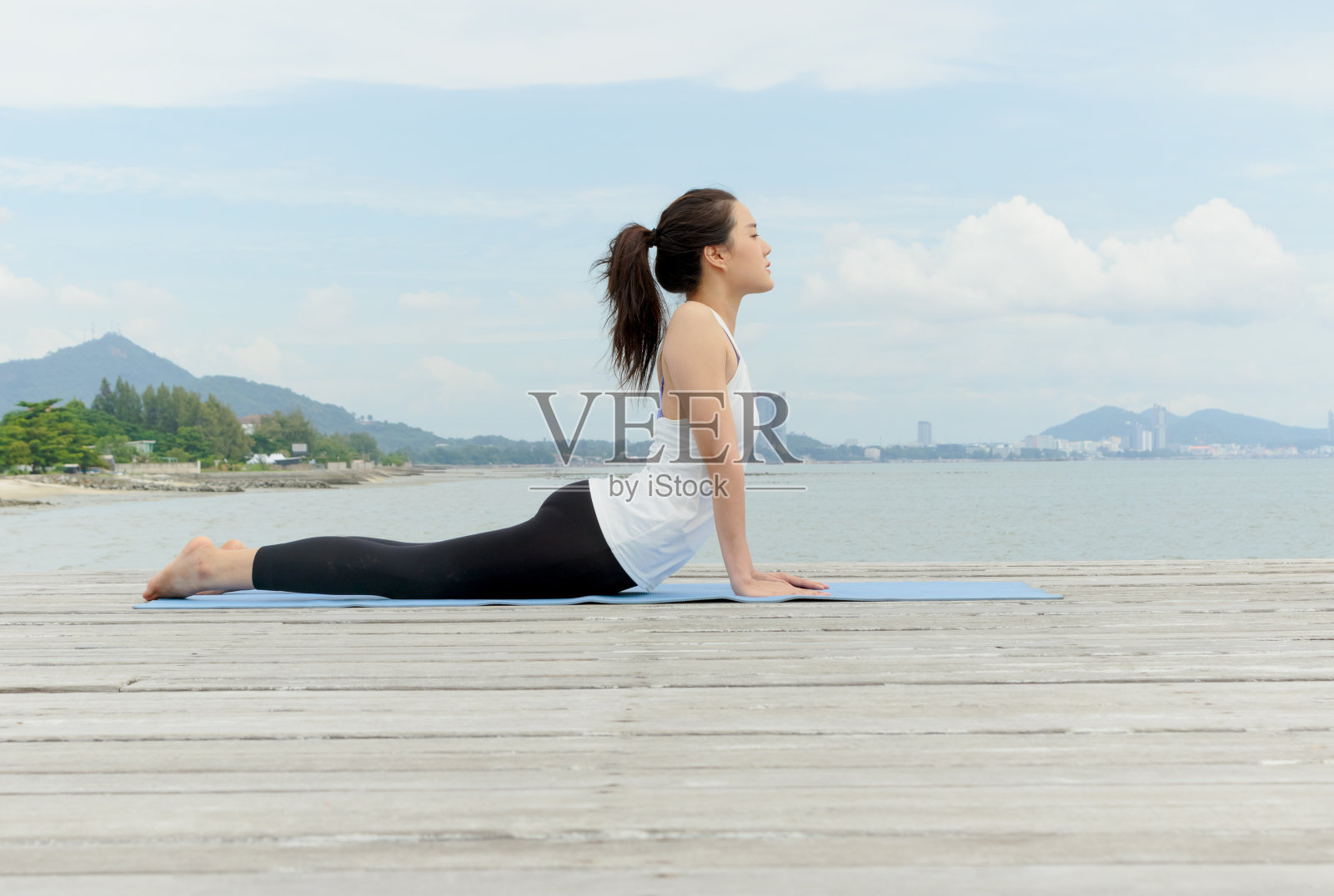 年轻的亚洲女子在海边练习瑜伽照片摄影图片
