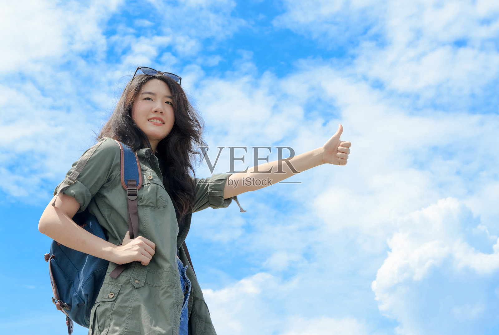 亚洲女游客搭便车在蓝天的背景照片摄影图片