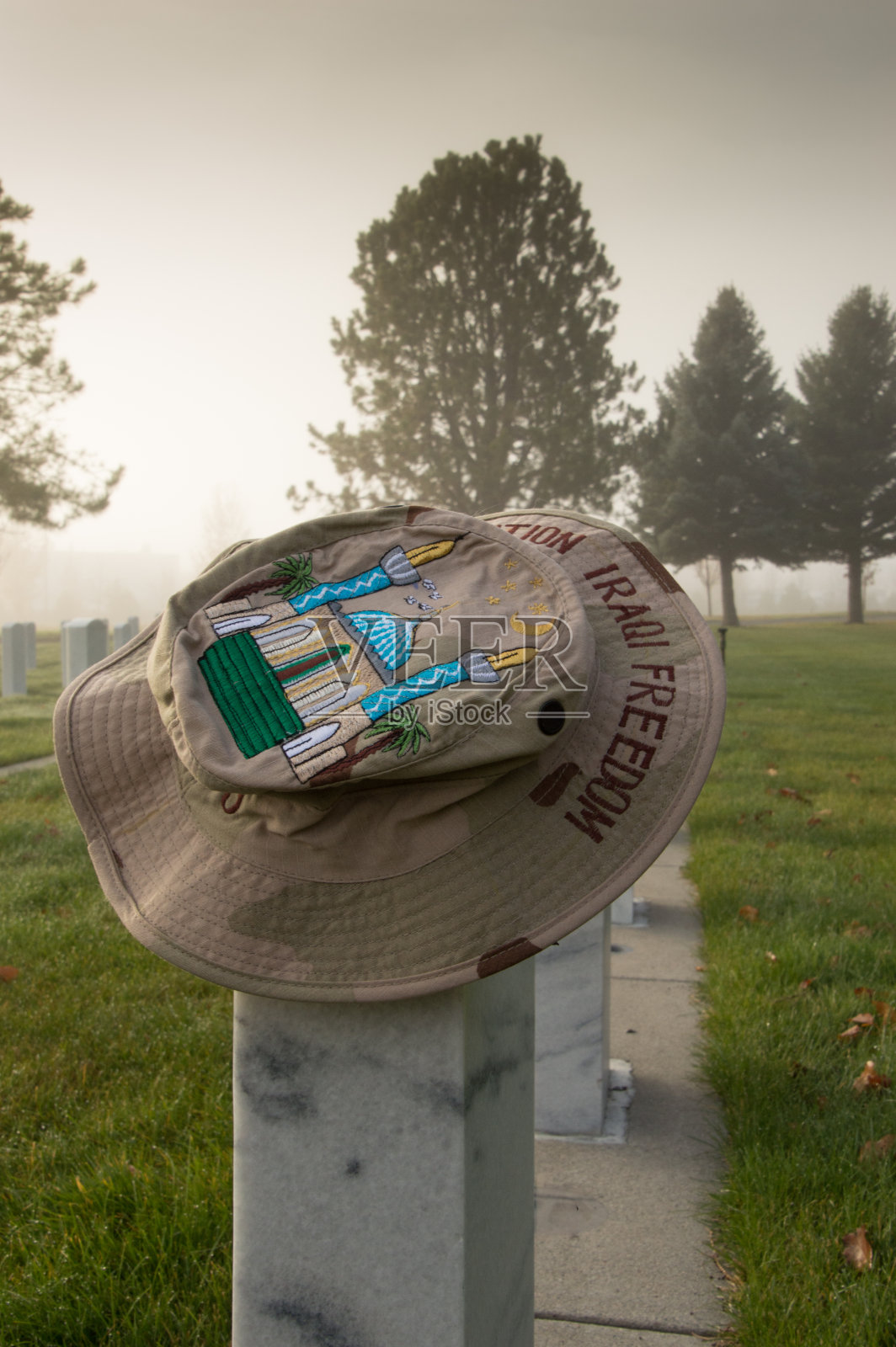 老兵墓碑上的迷彩帽照片摄影图片