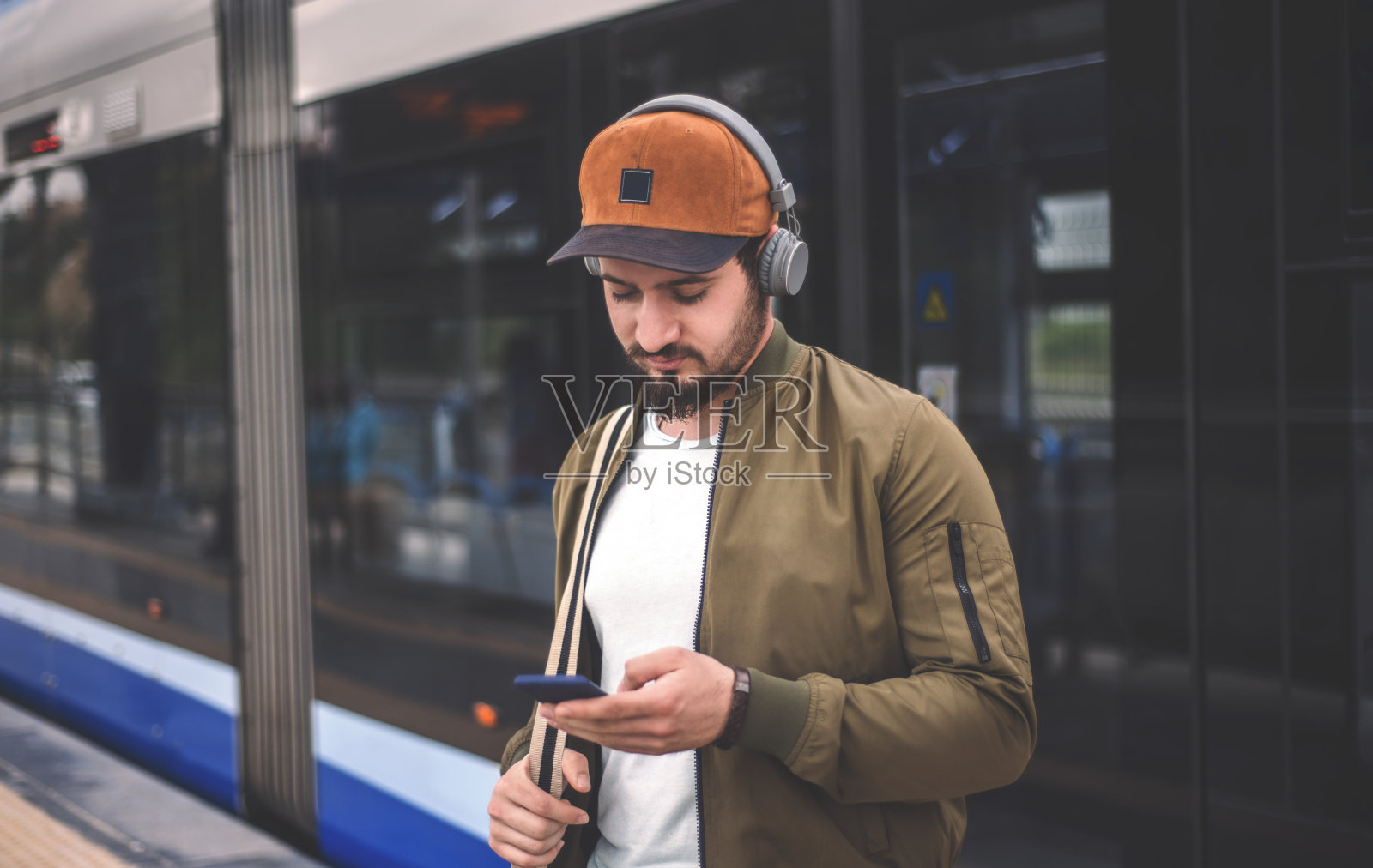 英俊的年轻人在火车站使用智能手机的肖像照片摄影图片