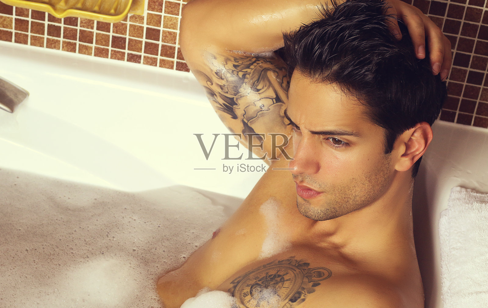 年轻的肌肉男正在洗澡。照片摄影图片