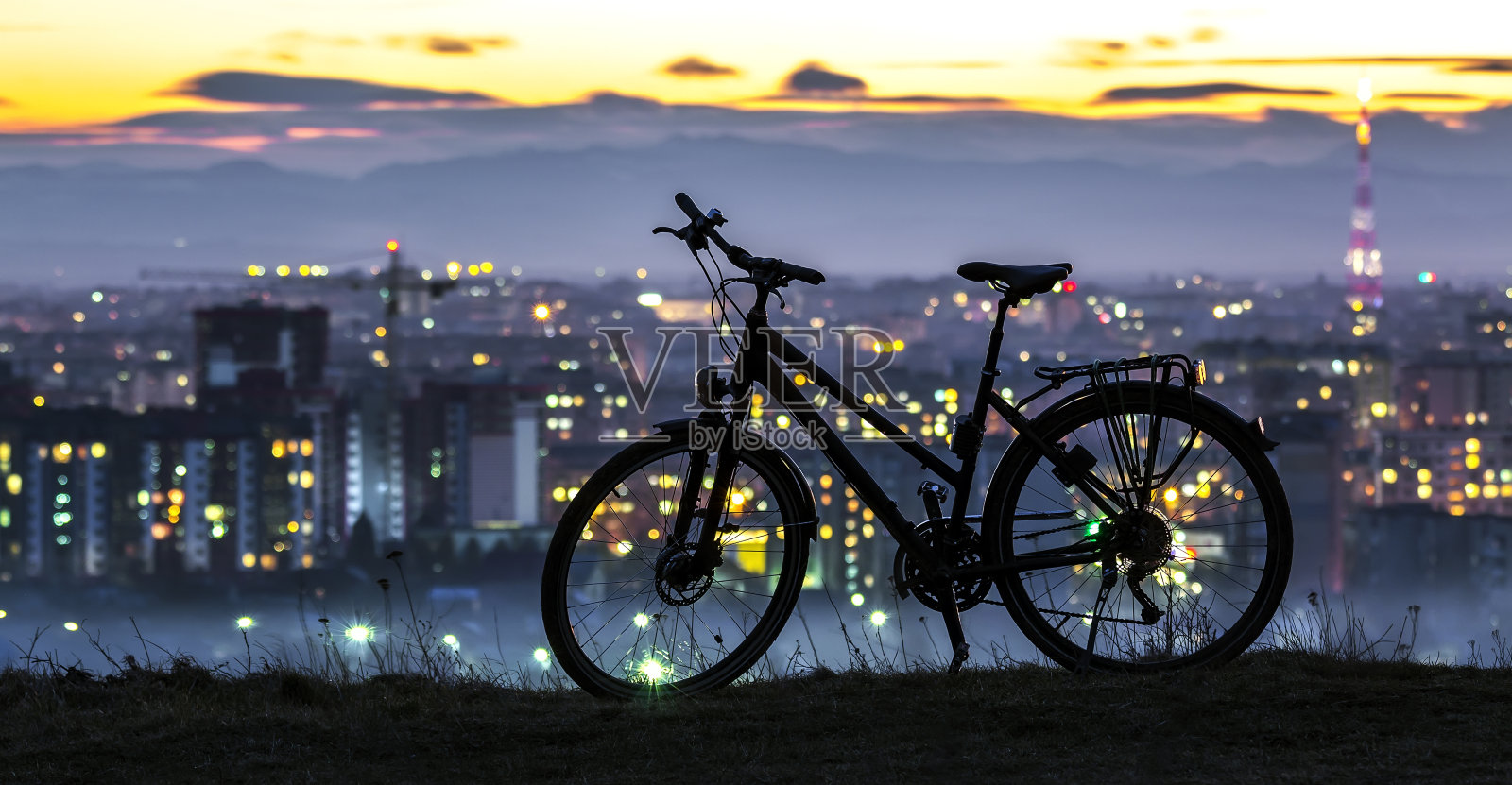 现代体育城市自行车独自站在夜晚的城市背景下照片摄影图片