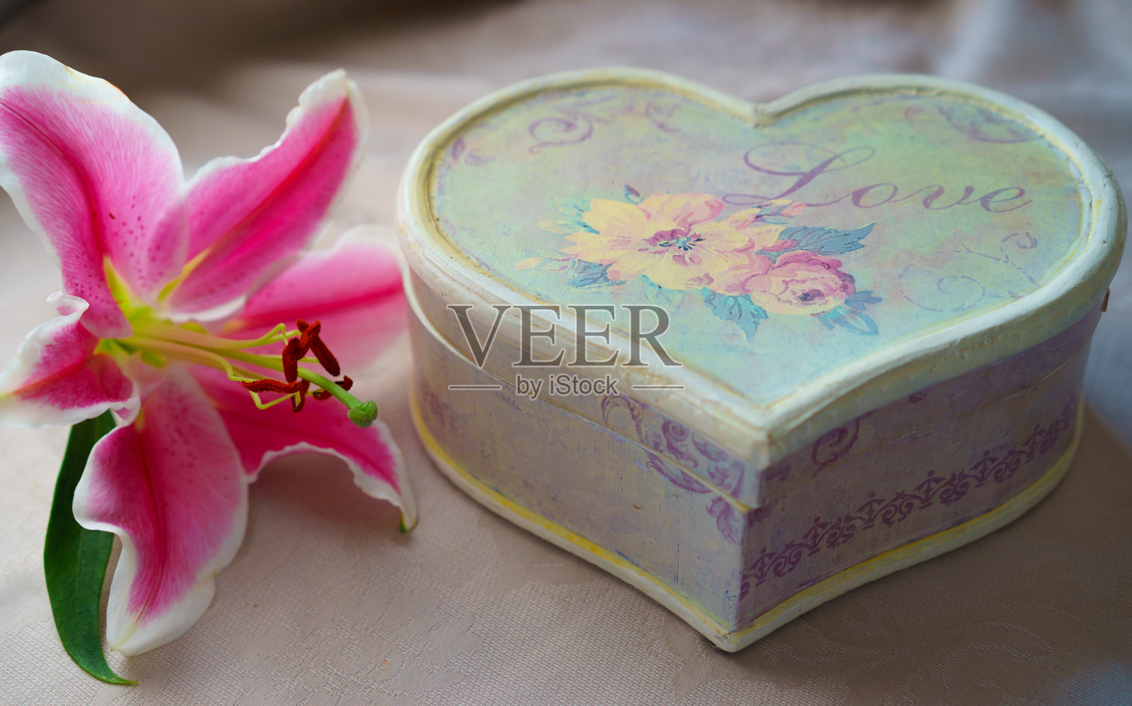 复古风格的粉色百合花束和手工心型工艺礼盒在天然色桌布上，情人节，婚礼，生日快乐，约会照片摄影图片