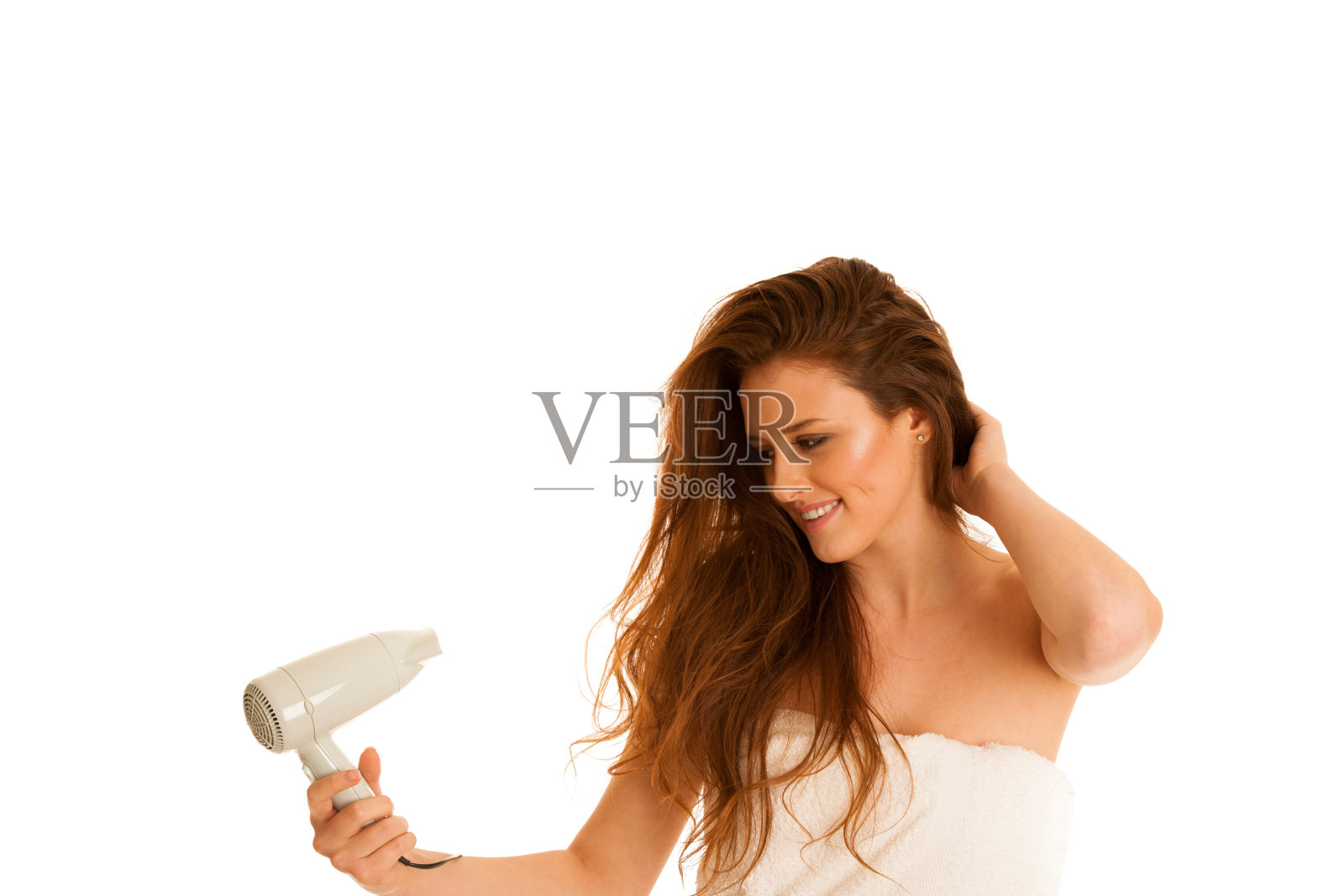 美丽的年轻女子用吹风机吹干头发照片摄影图片