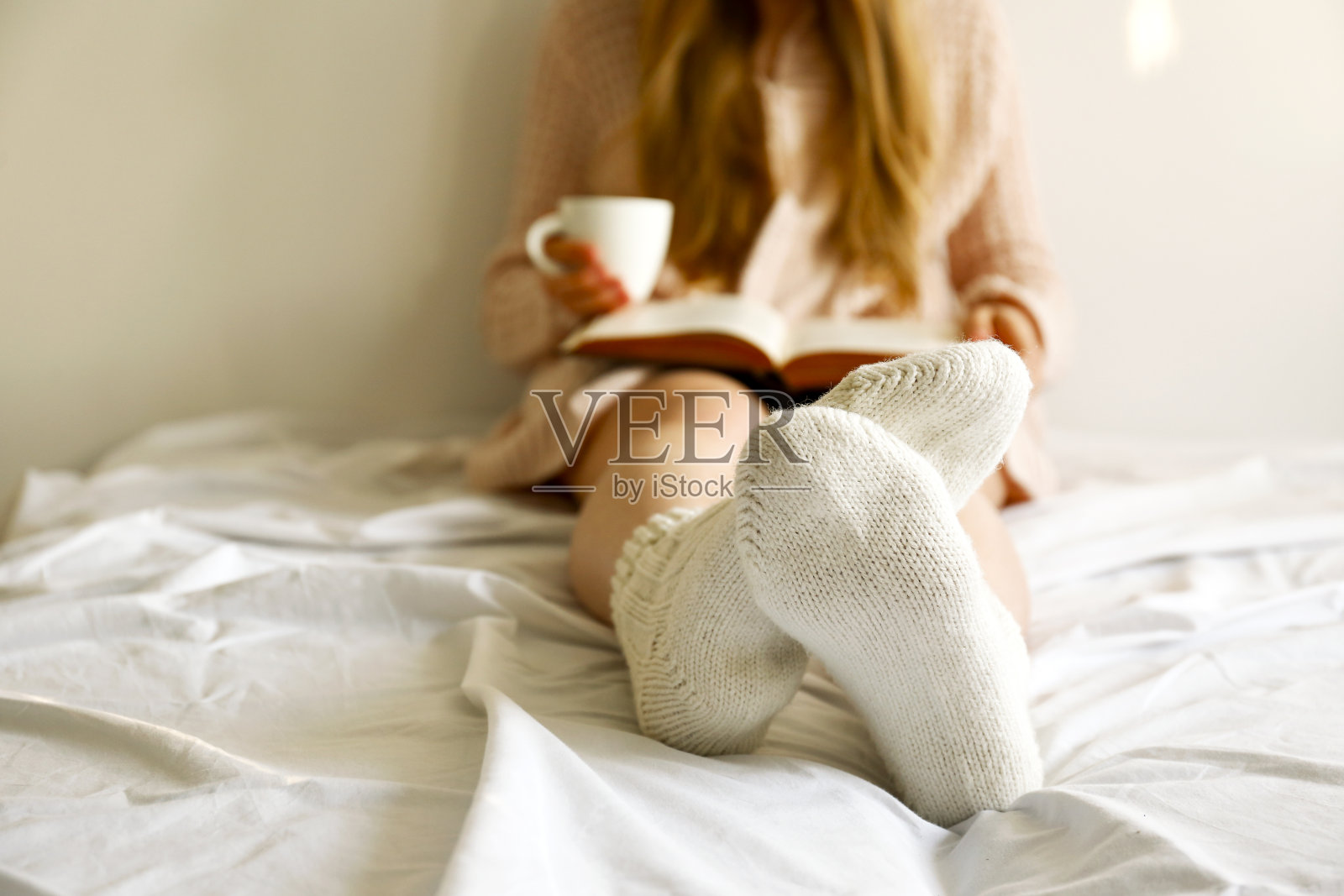 年轻女子坐在家里。闭合女性的腿干净的剃须与光滑的皮肤。照片摄影图片