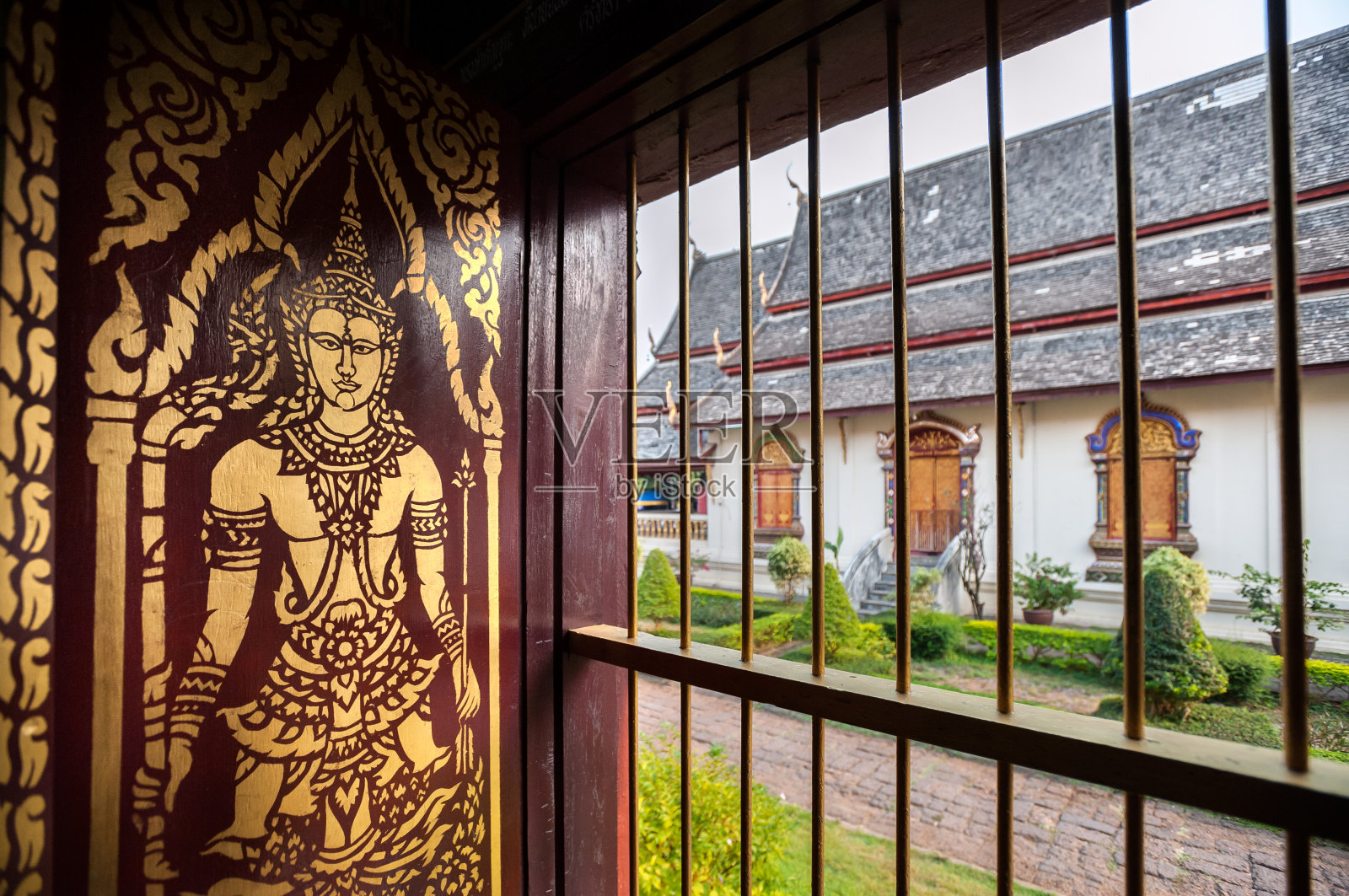 泰国清迈，清曼寺的主寺内，木制百叶窗上的金色佛像照片摄影图片