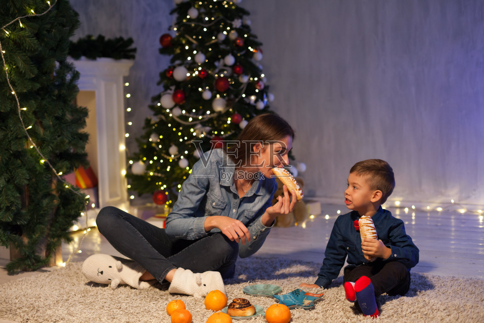 母亲和儿子在圣诞晚餐加兰灯新年礼物照片摄影图片