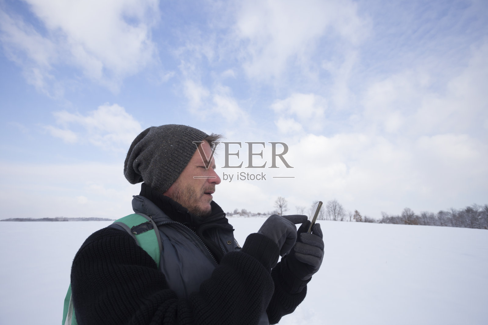 英俊的成年男子徒步在雪地上使用手机户外照片摄影图片