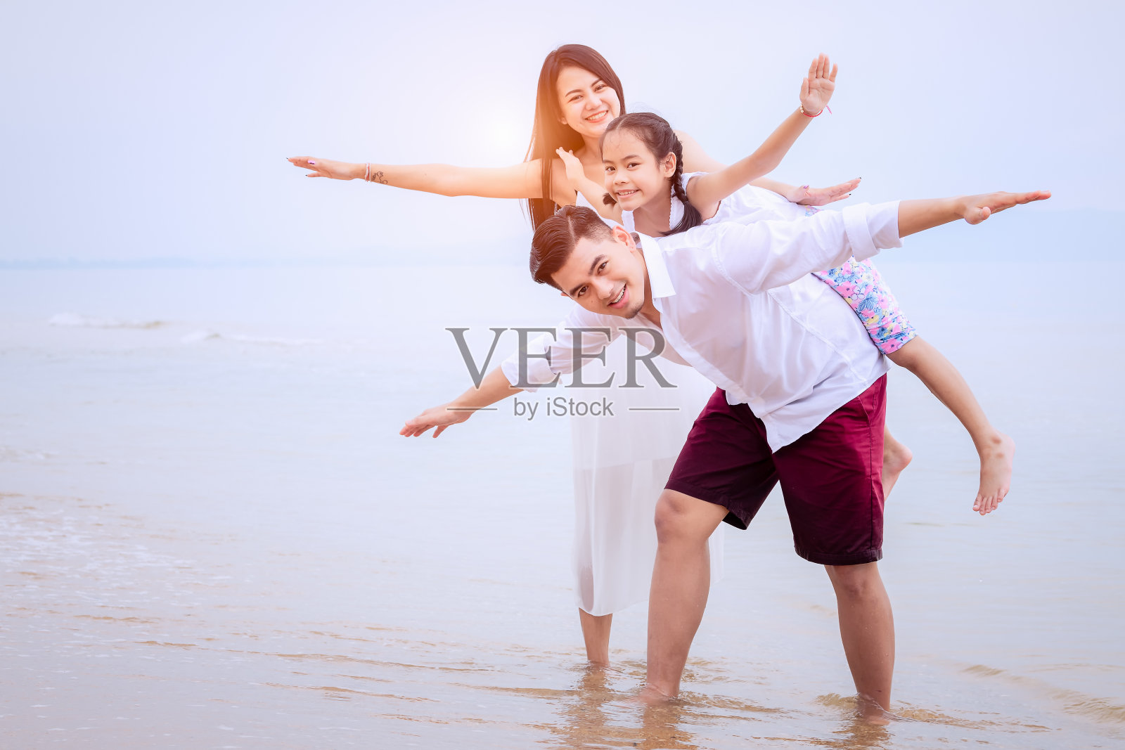 家人一起在海滩上放松。照片摄影图片