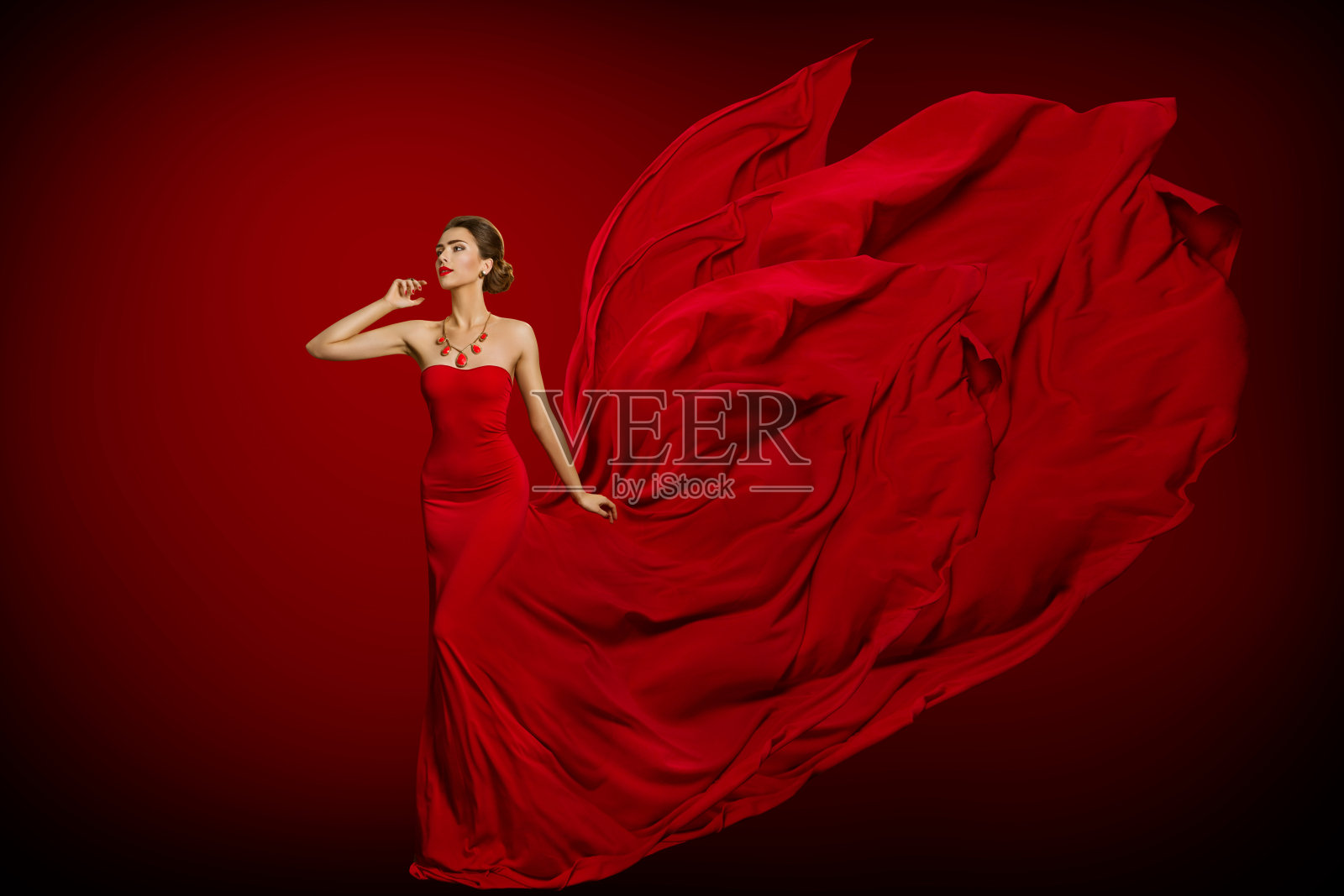 时装模特红色火红的裙子，女人在长飘扬挥舞长袍尾巴照片摄影图片