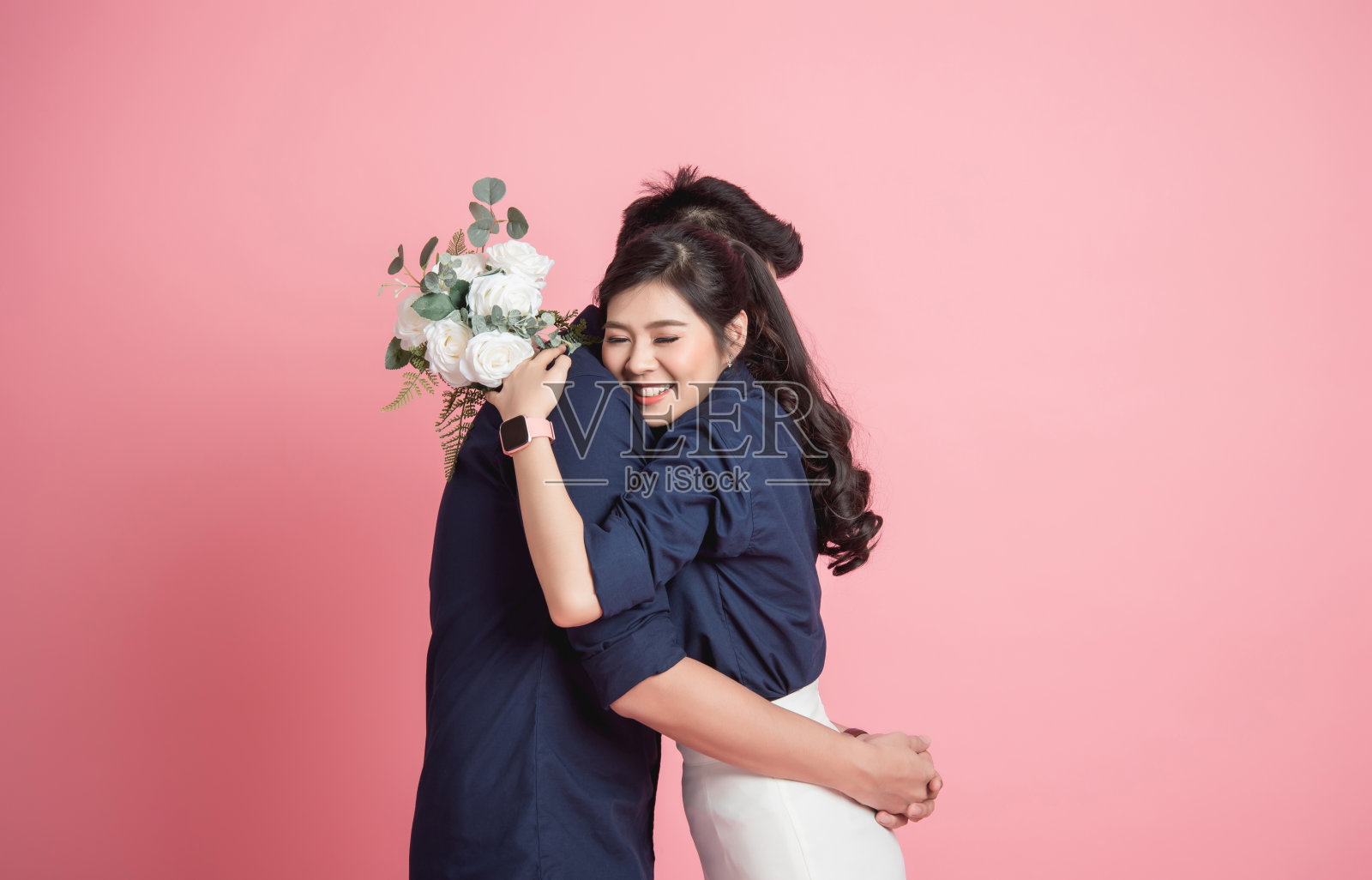 亚洲女子抱着她的男友，手里拿着一束花照片摄影图片