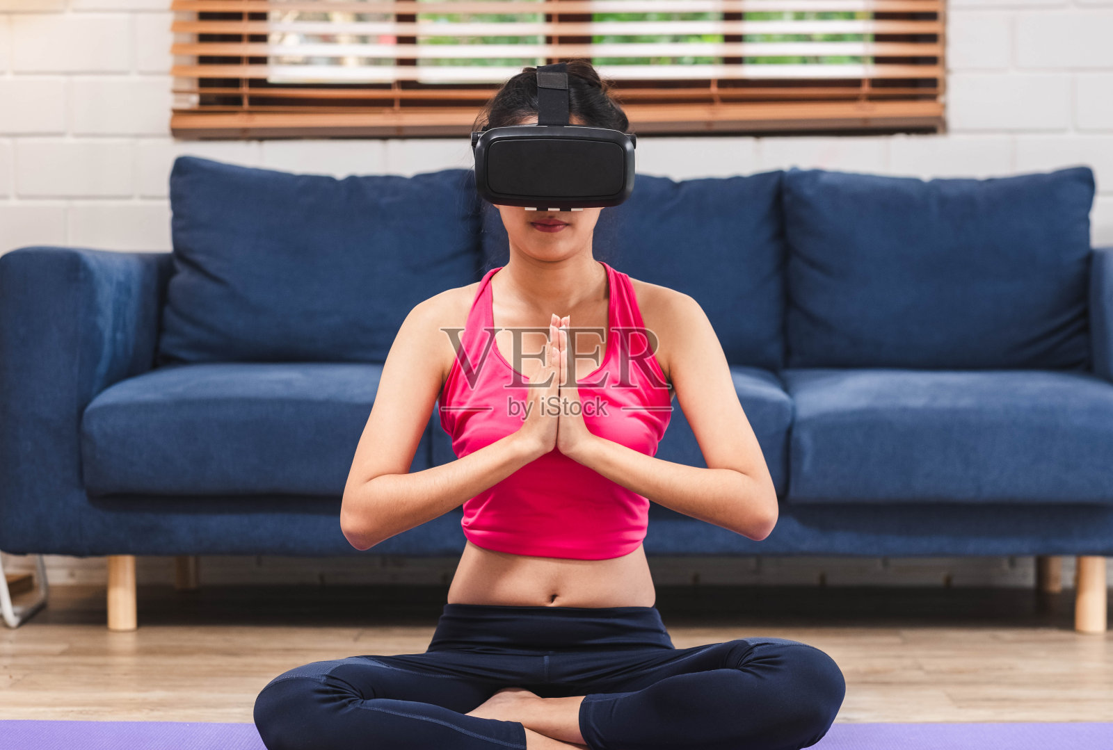 亚洲女性使用虚拟现实眼镜耳机在家里客厅地板上在线训练瑜伽姿势。自我学习,照片摄影图片