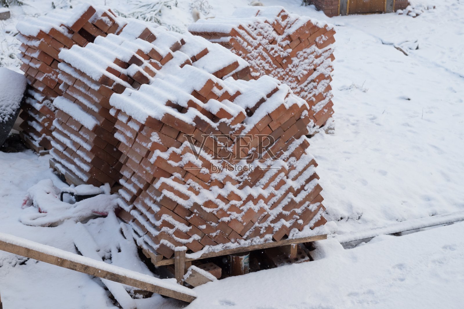 冬天，雪花飘落，铺满了红砖，站在院子里。照片摄影图片
