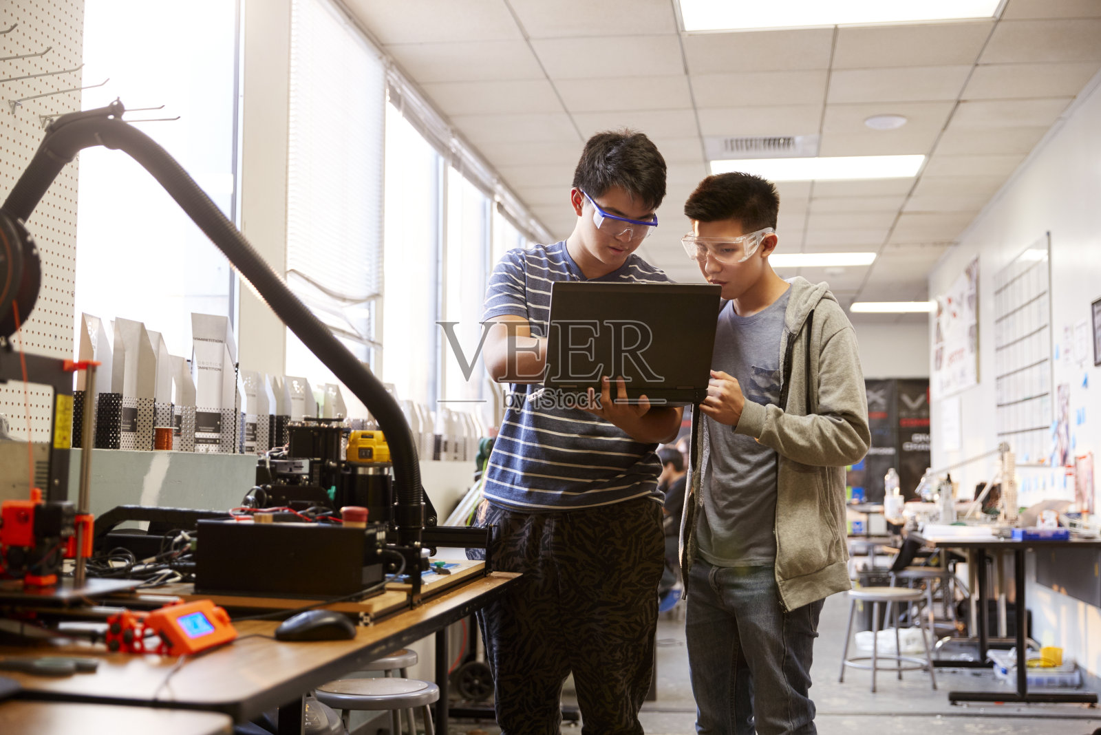 两个男大学生在科学机器人或工程课上使用笔记本电脑照片摄影图片