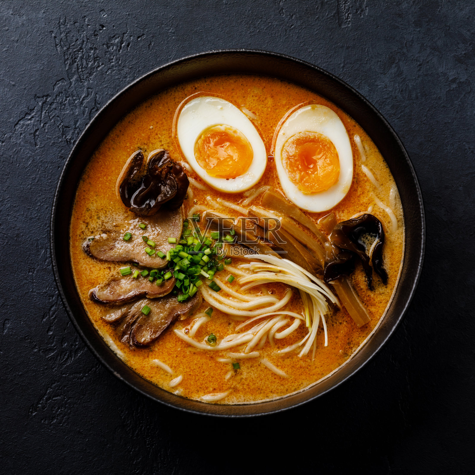 亚洲拉面汤汁牛肉舌肉，蘑菇和Ajitama腌制鸡蛋在碗中深色背景照片摄影图片