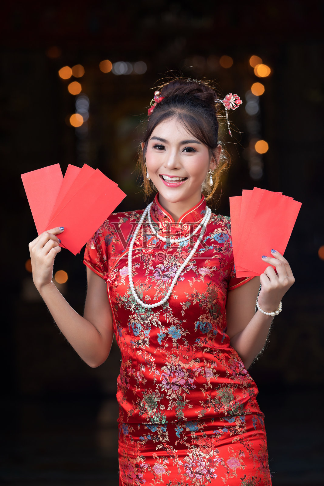 中国女孩的肖像，中国妇女穿着传统服装旗袍，拿着红包或礼券奖励在中国农历新年的神社，中国女孩。照片摄影图片