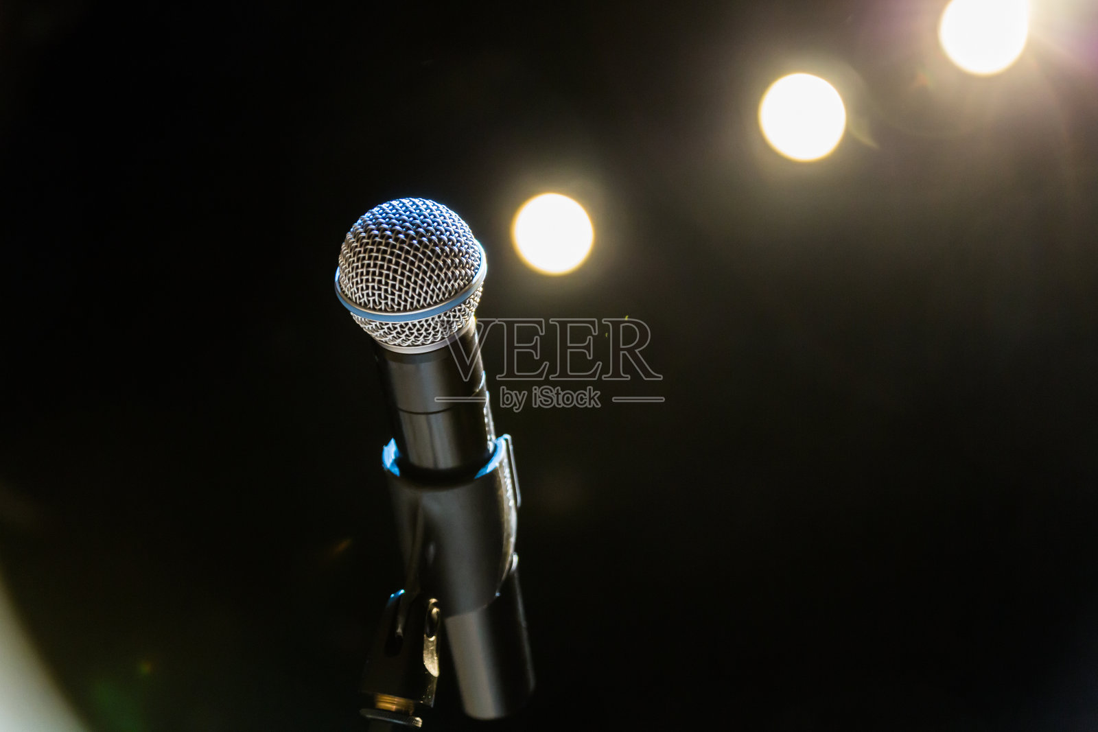 无线麦克风站在舞台聚光灯的背景上照片摄影图片
